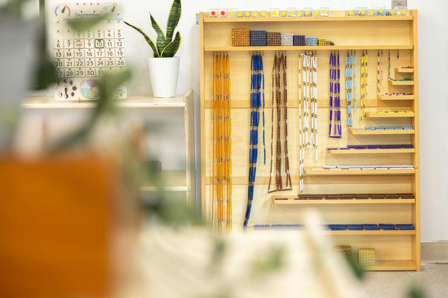 Wooden shelving unit displaying various strands and clusters of colorful beads