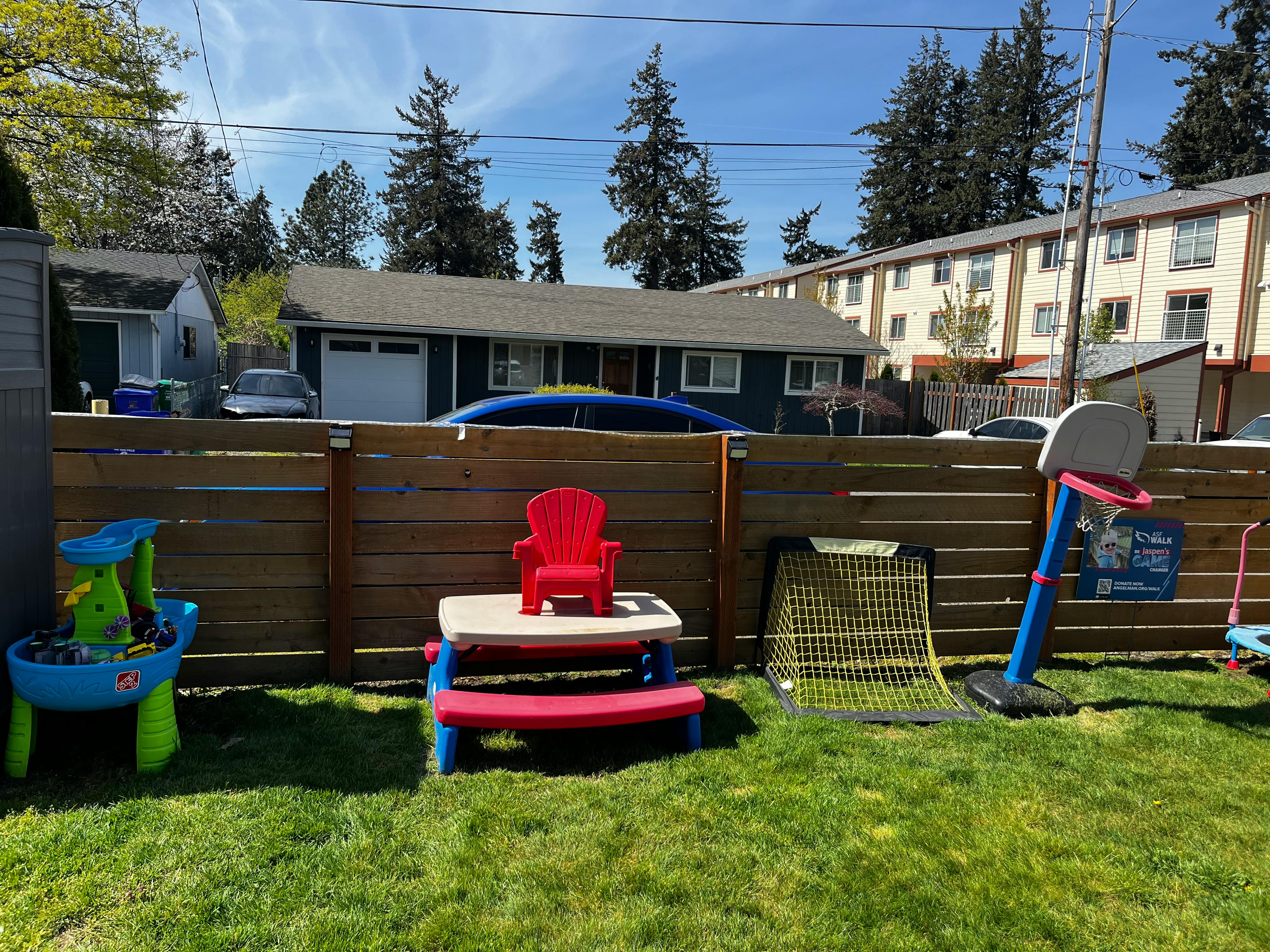 Backyard with children's play table, chair, and basketball hoop