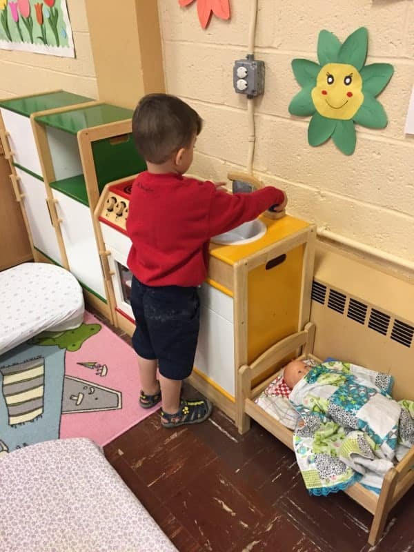 Child playing with a toy kitchen set