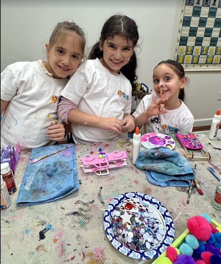 Three children at a table with art supplies