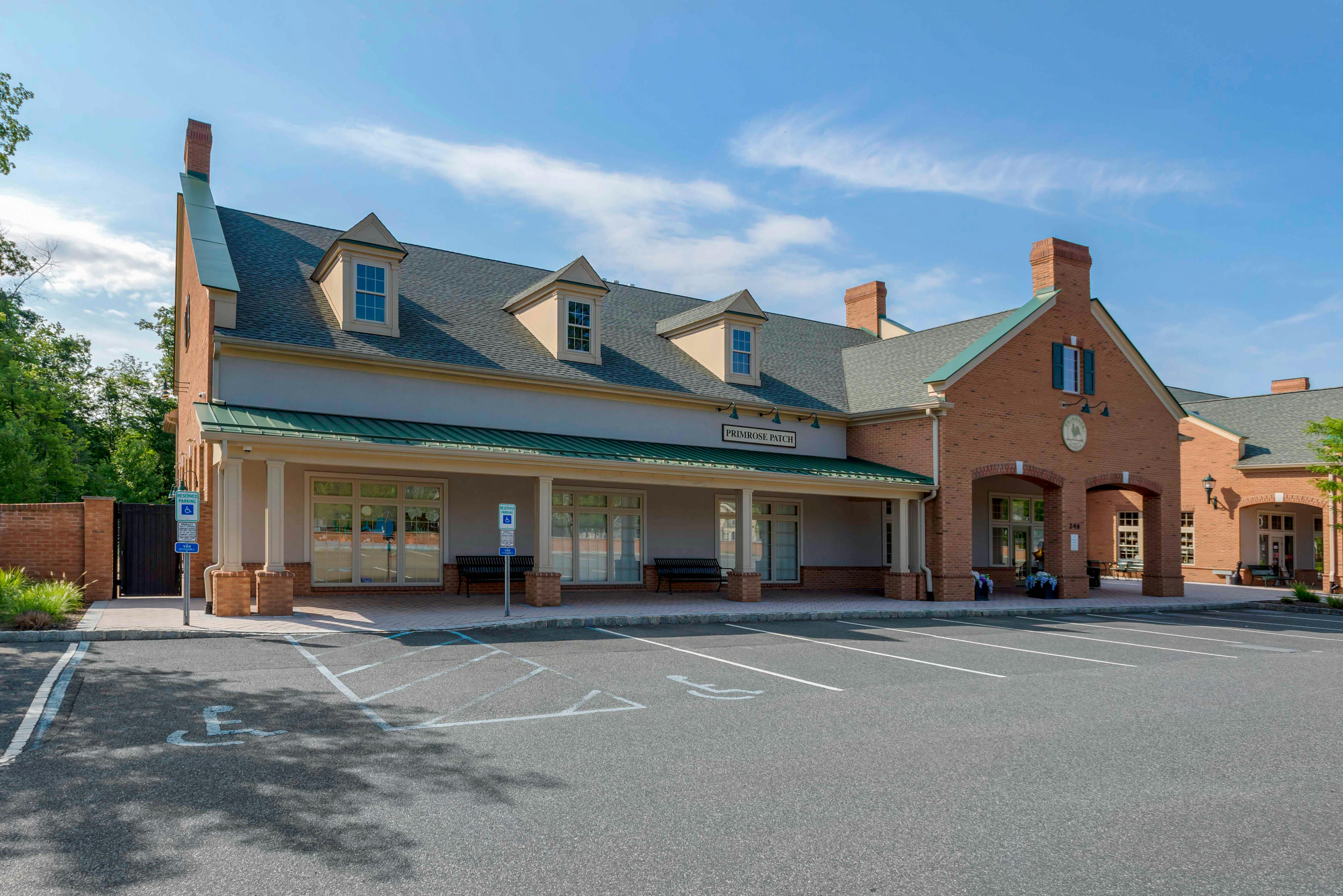 Building with "Primrose Patch" sign above entrance and parking lot