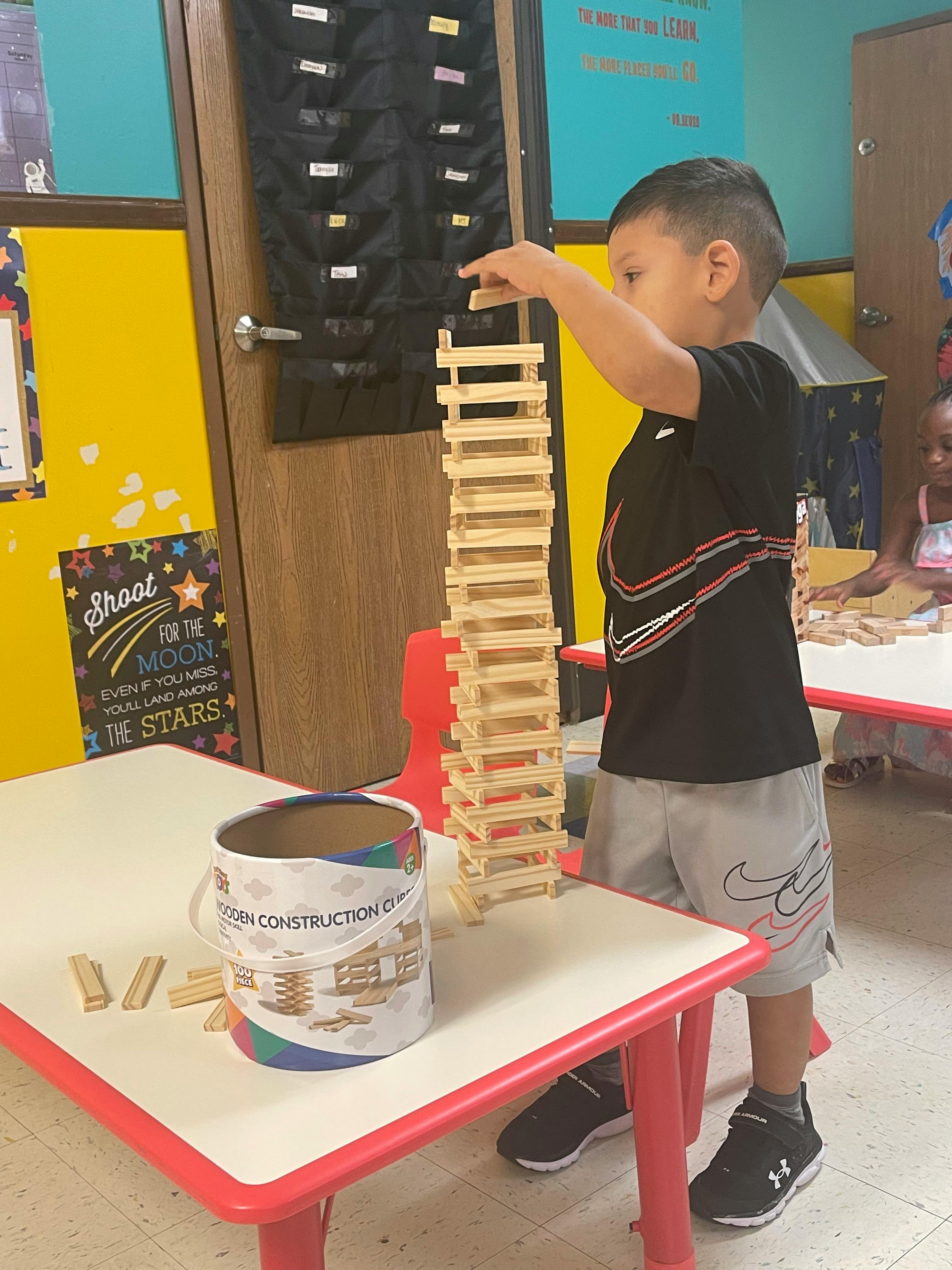Child stacking wooden blocks on a table