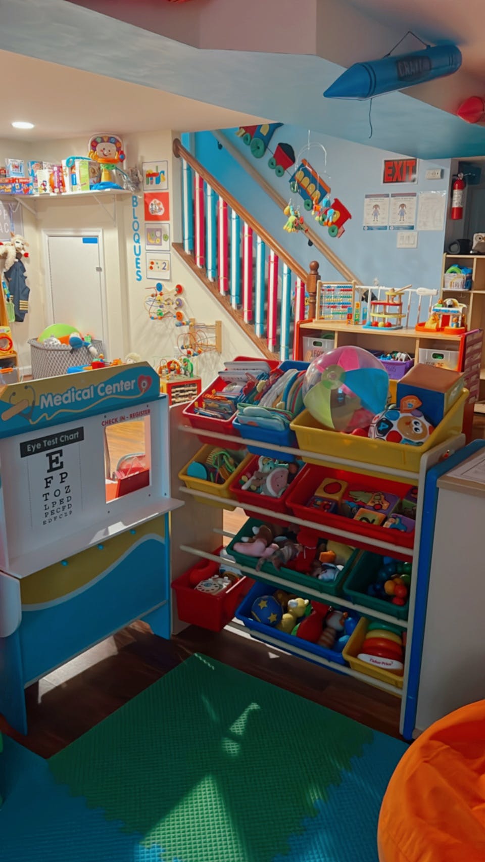 Playroom with toy storage, play medical center, and stairs
