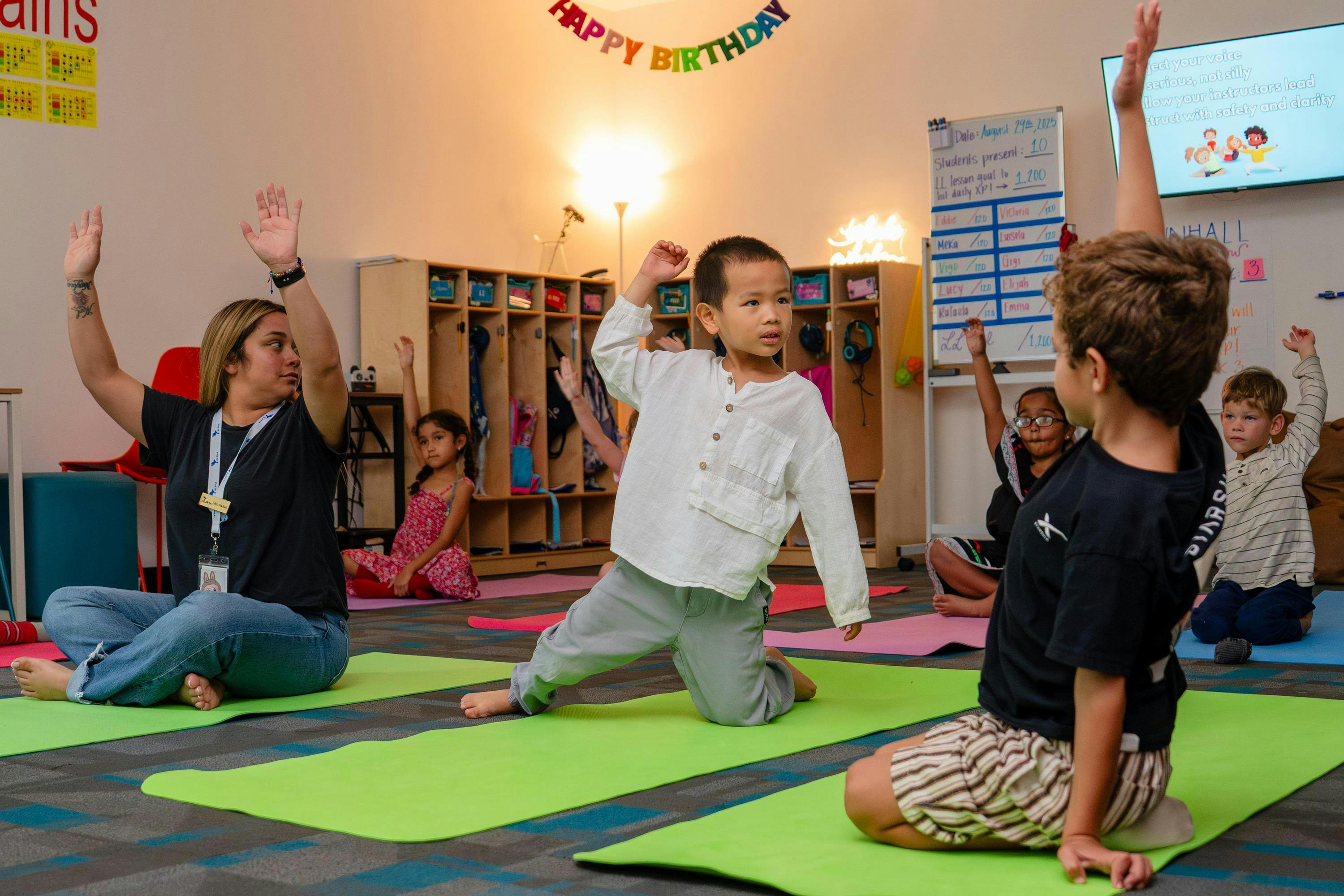Adult and children doing yoga in a classroom