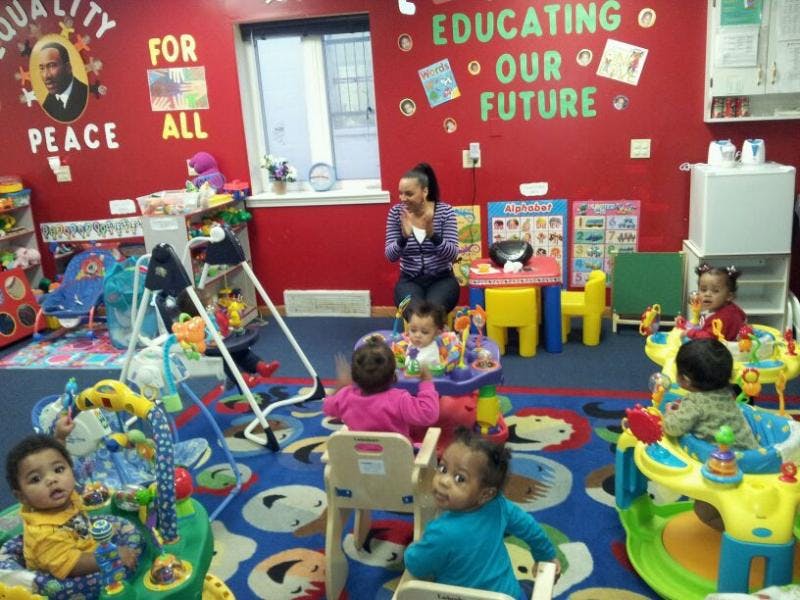 Adult and multiple children in a colorful room with toys