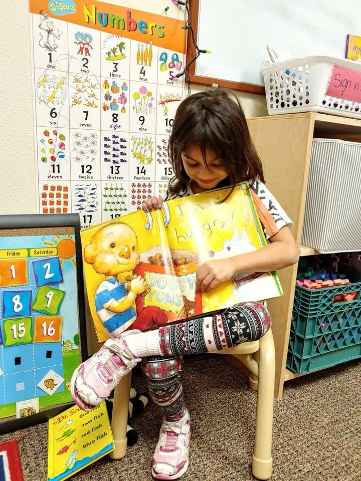 Child sitting on a chair and reading a book