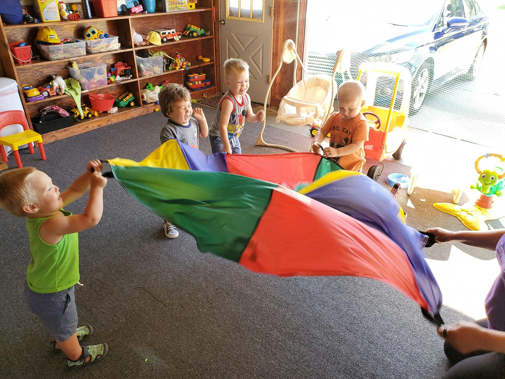Children playing with a colorful parachute