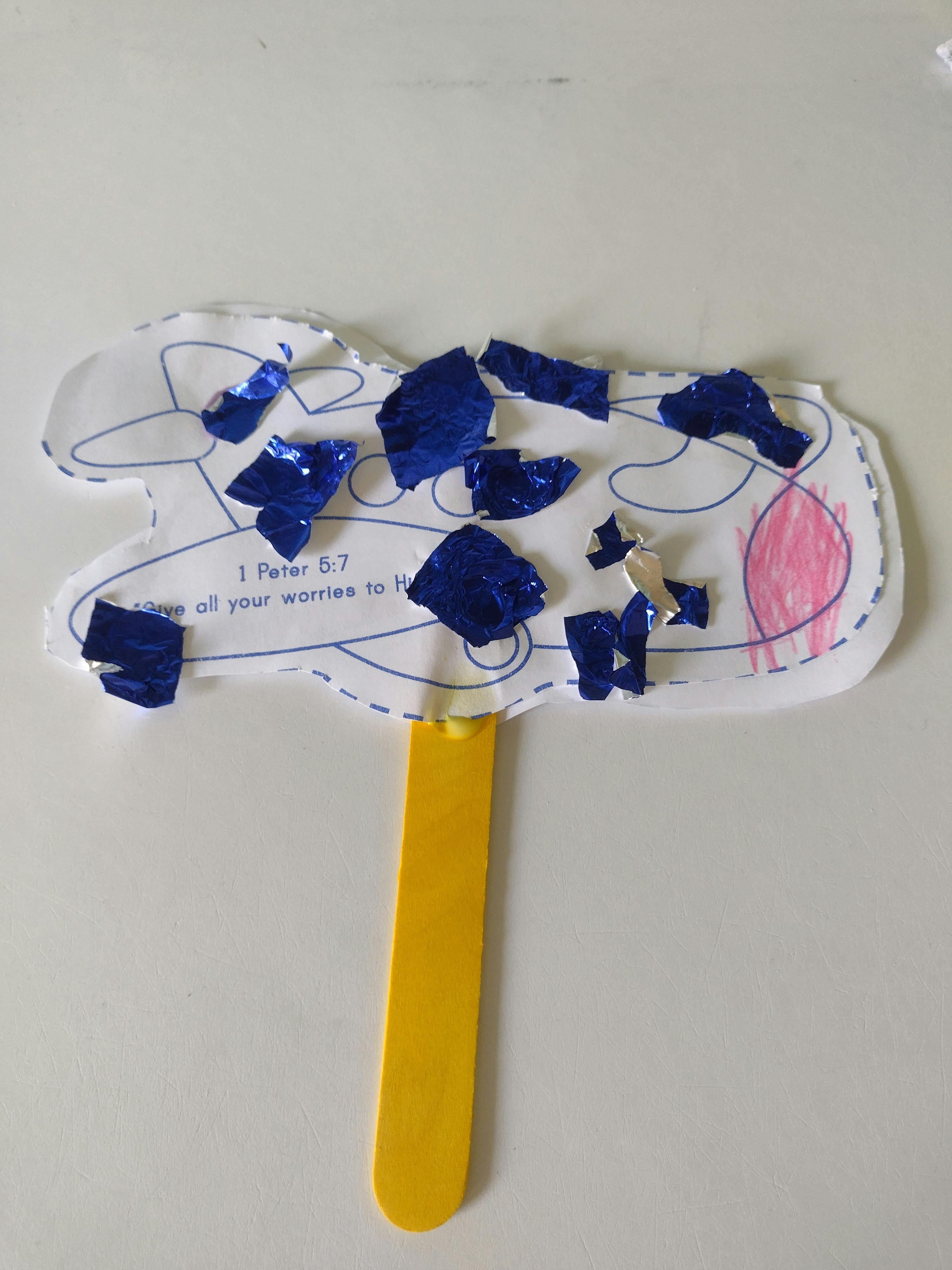 Craft of a sheep with blue foil pieces and text "1 Peter 5:7"