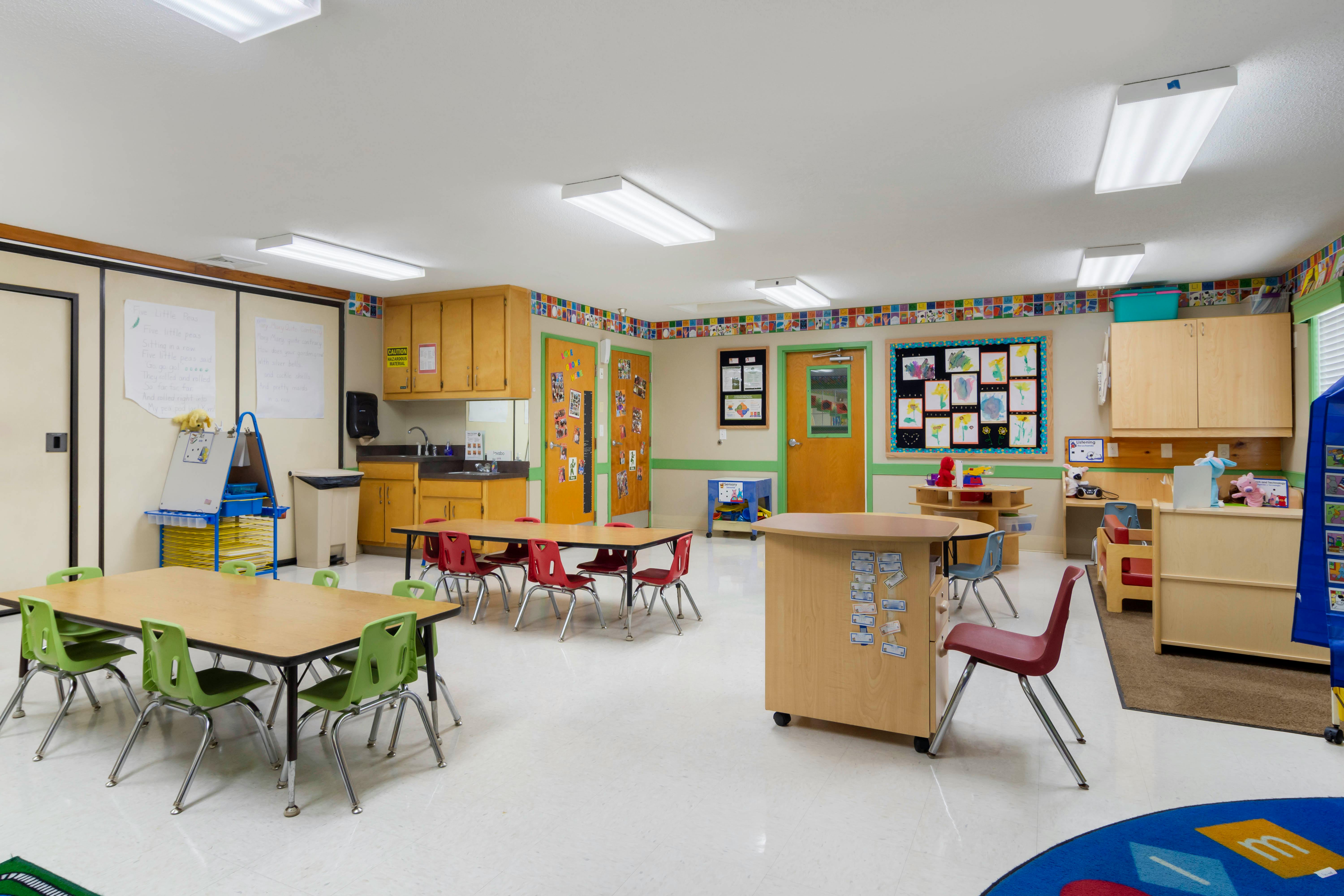 Empty classroom with small tables and chairs for children