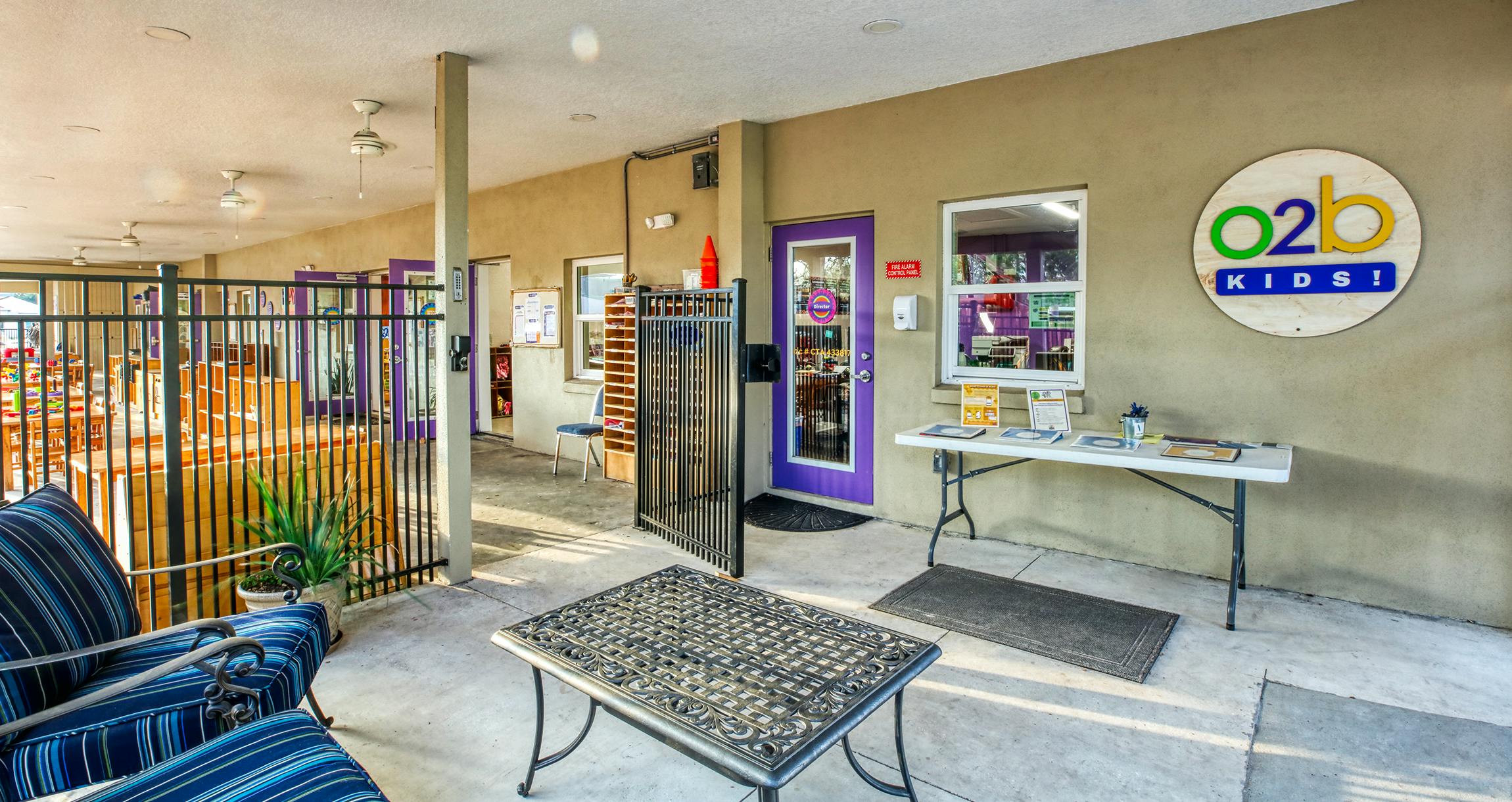Entrance to O2B Kids childcare center with patio furniture