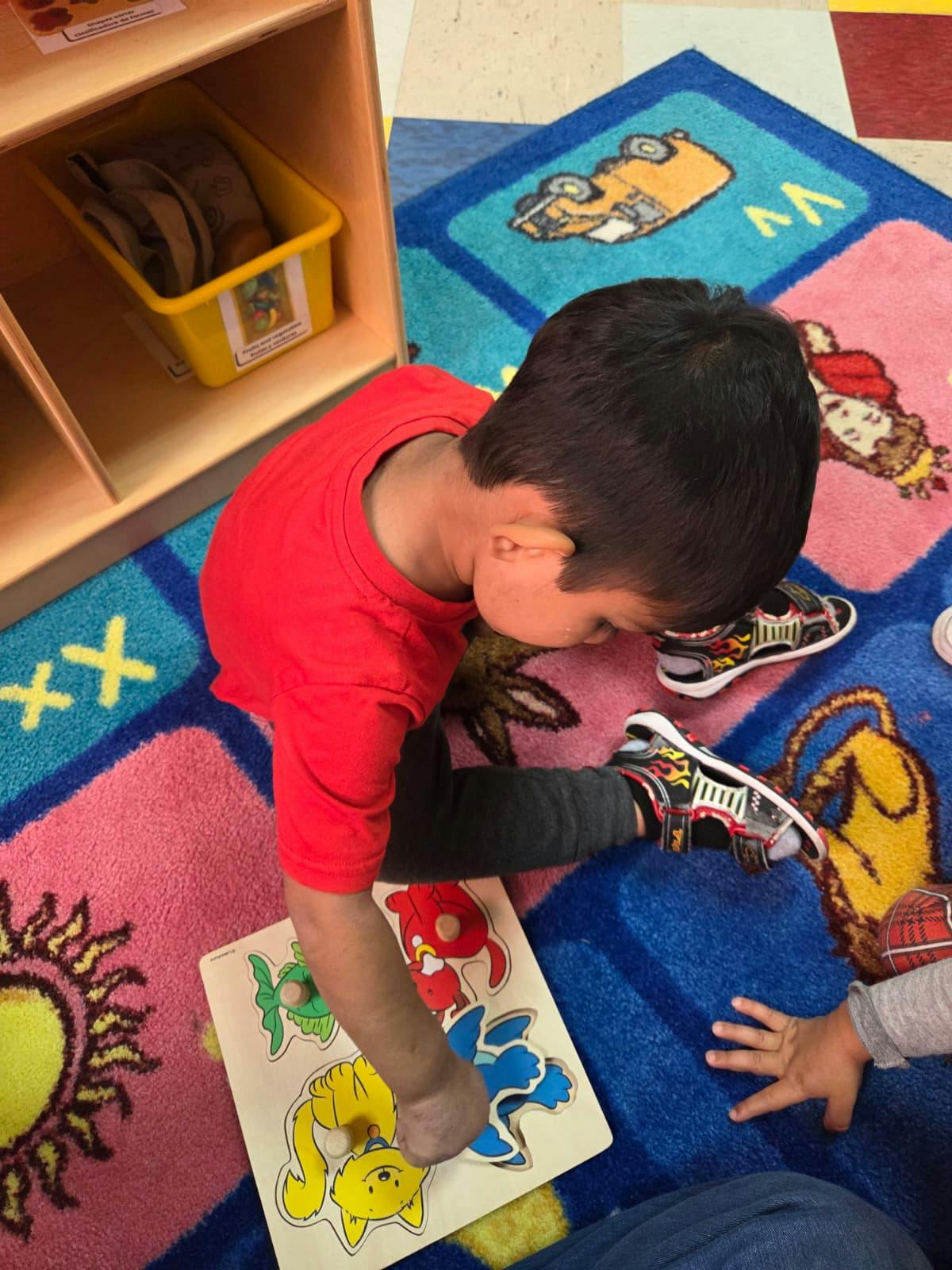 Child on a colorful rug playing with a wooden puzzle