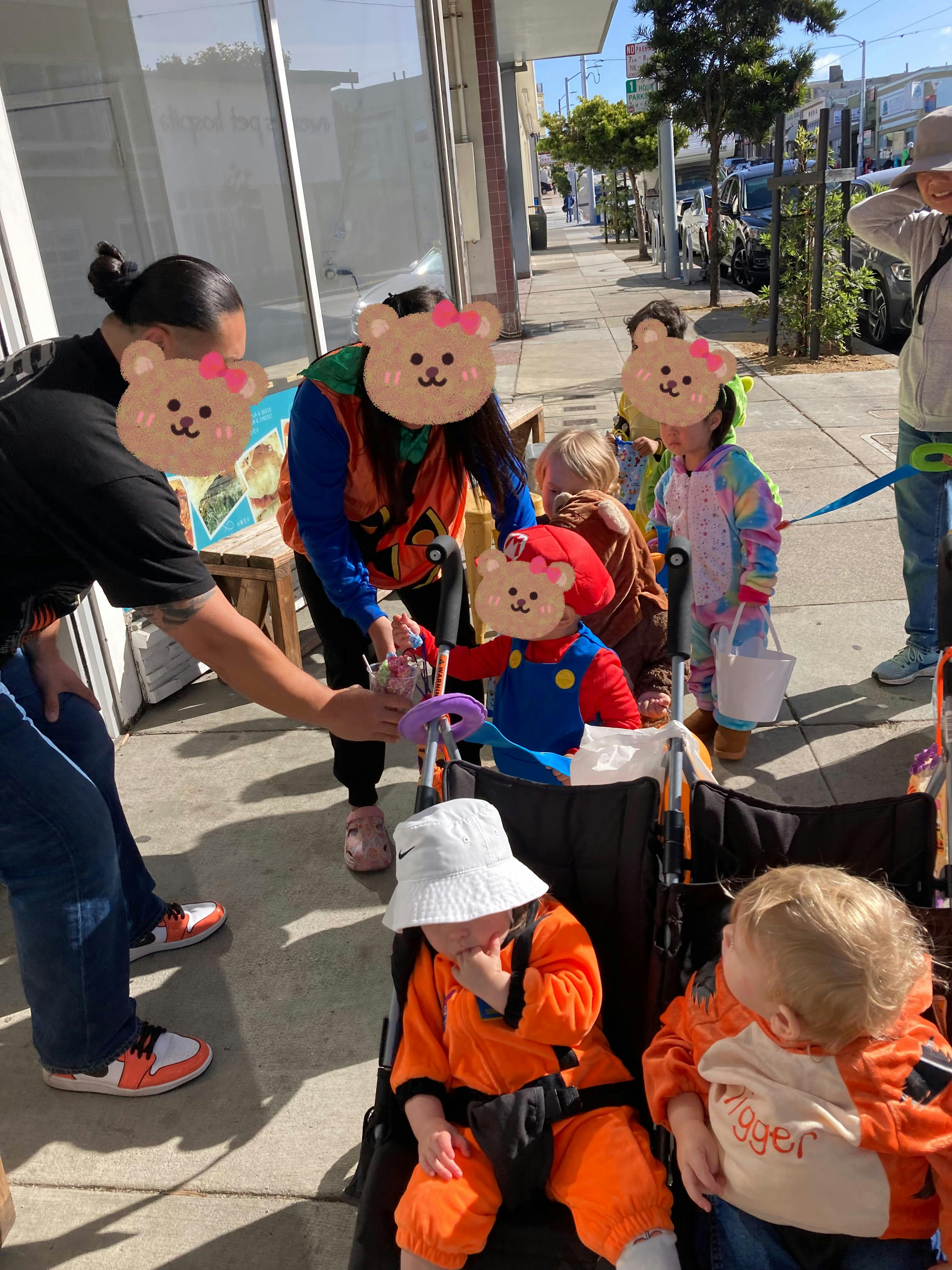 People and children in costumes on a sidewalk