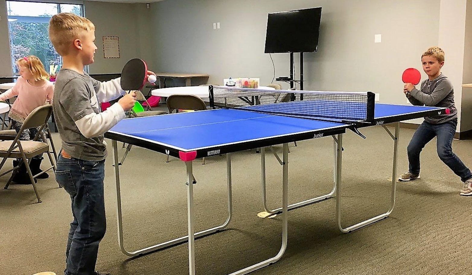 Two children playing table tennis