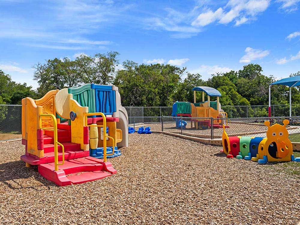 Colorful playground structures with wood chips on the ground