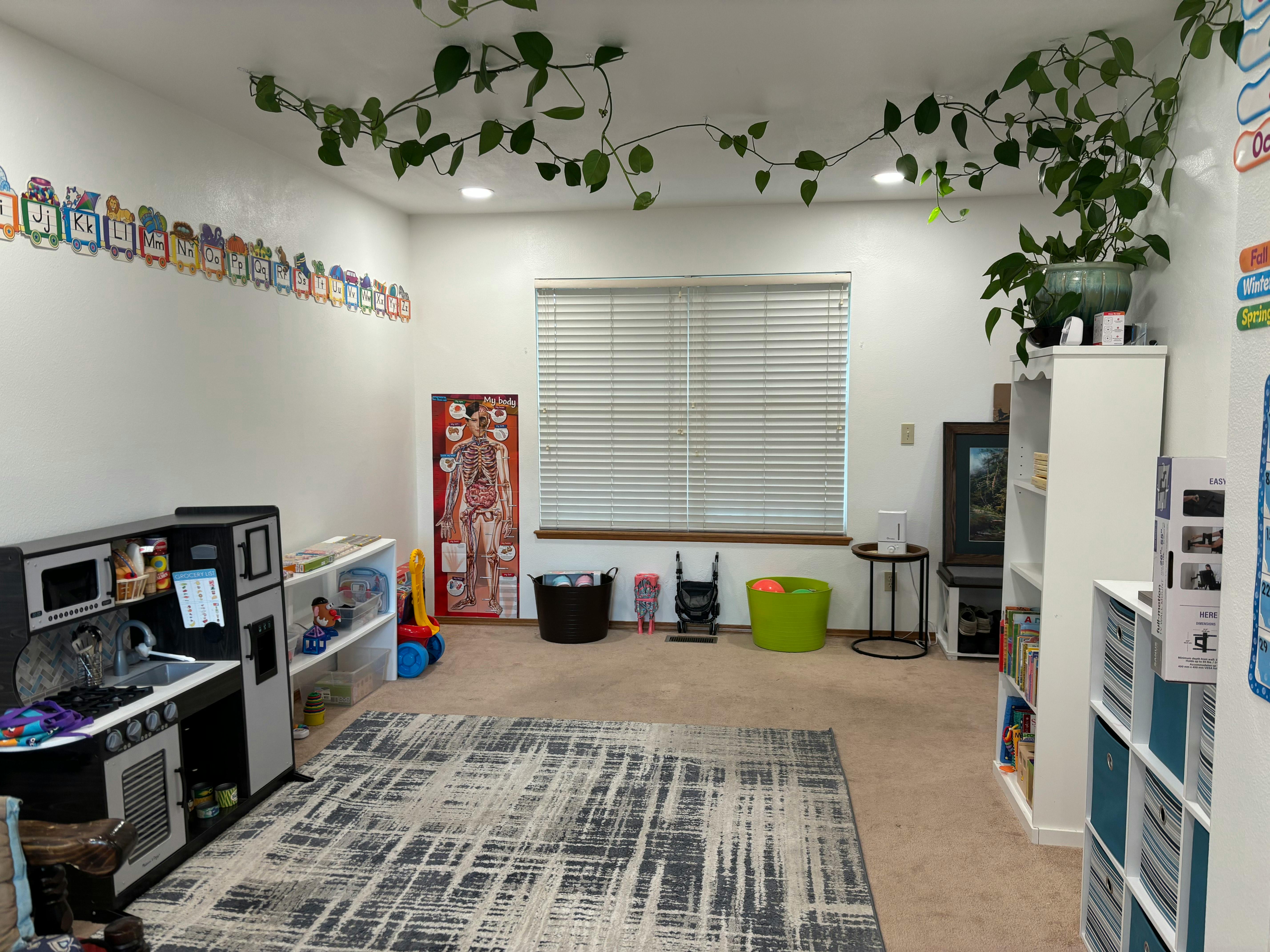 Playroom with toy kitchen, rug, and window