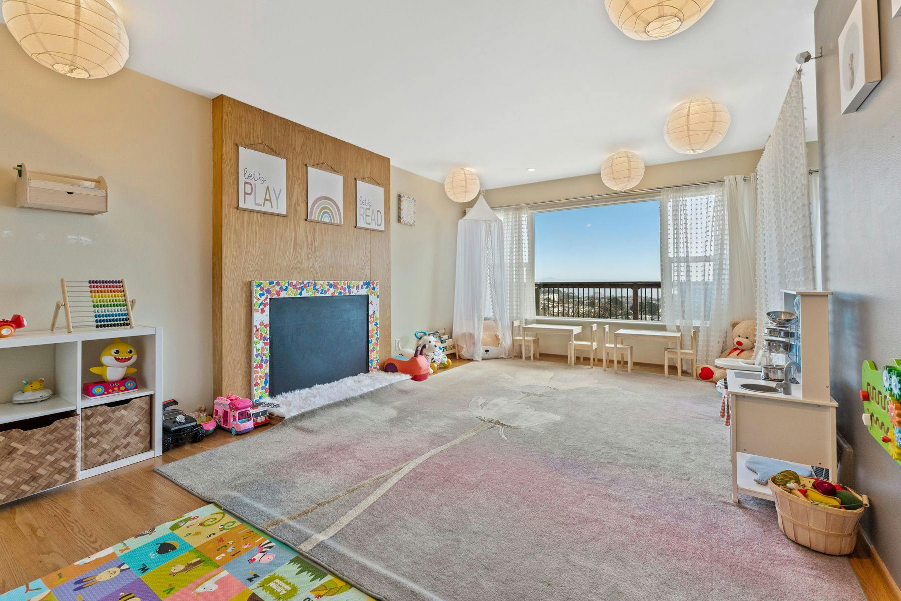 Playroom with toys, a chalkboard, and a large window