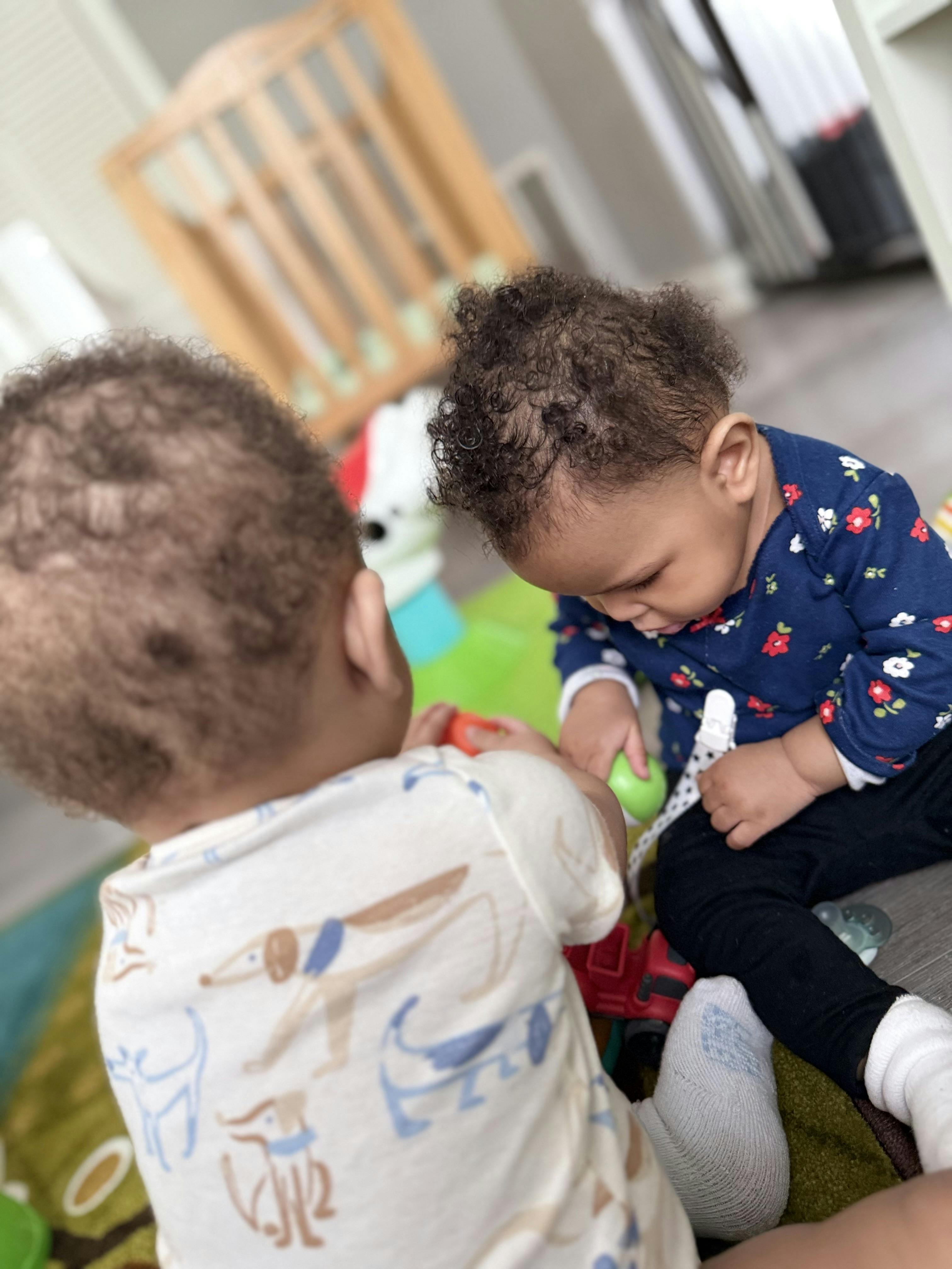 Two children playing on the floor with toys