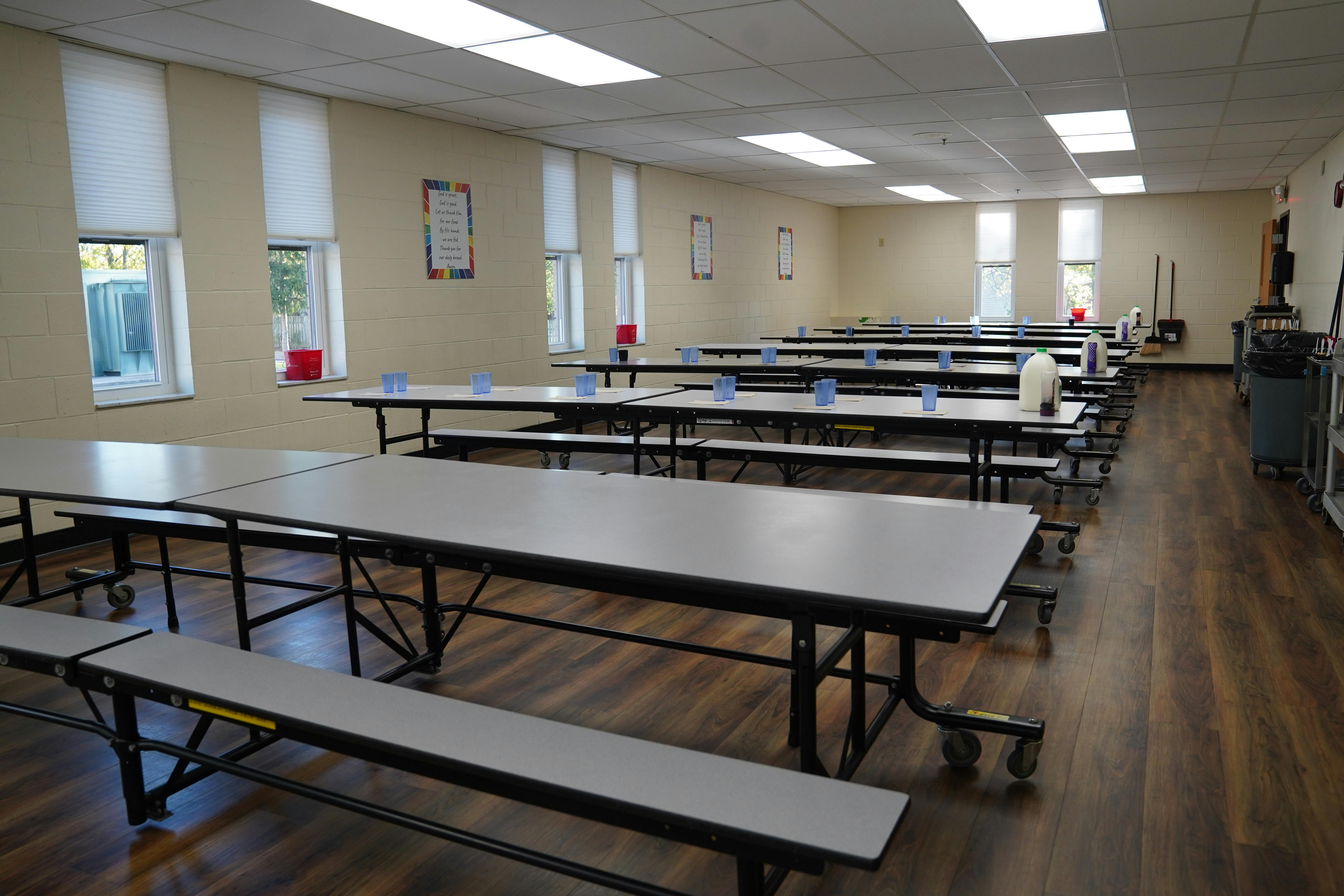 Empty cafeteria with rows of tables and benches