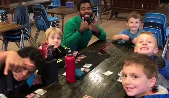 Adult and children sitting at a table with cards