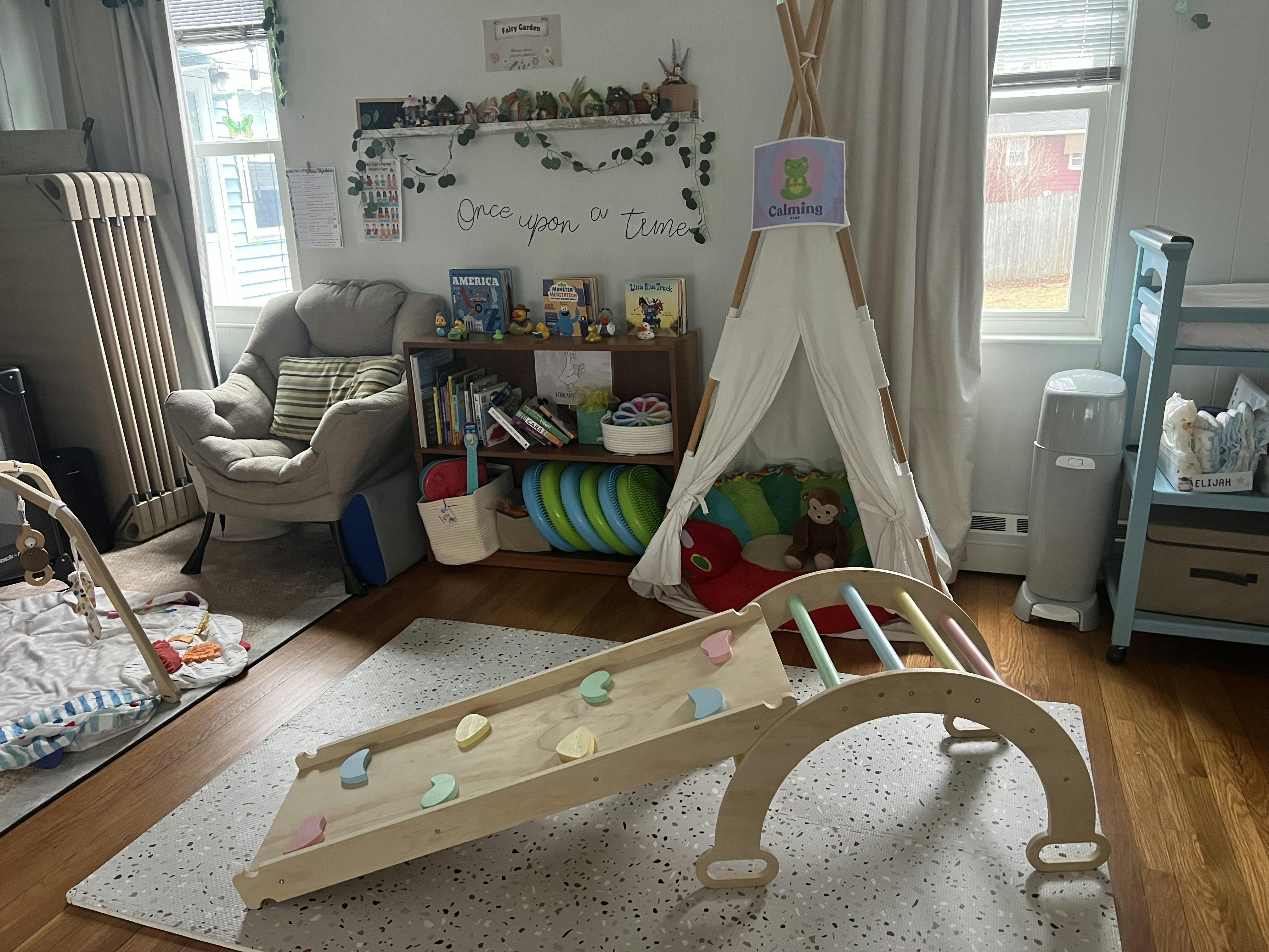 Child's playroom with a tent, wooden slide, armchair, and bookshelf