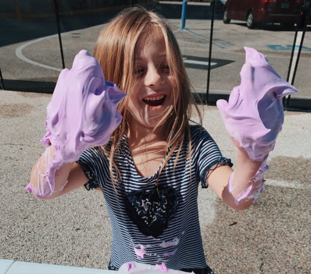 Child holding purple slime in both hands