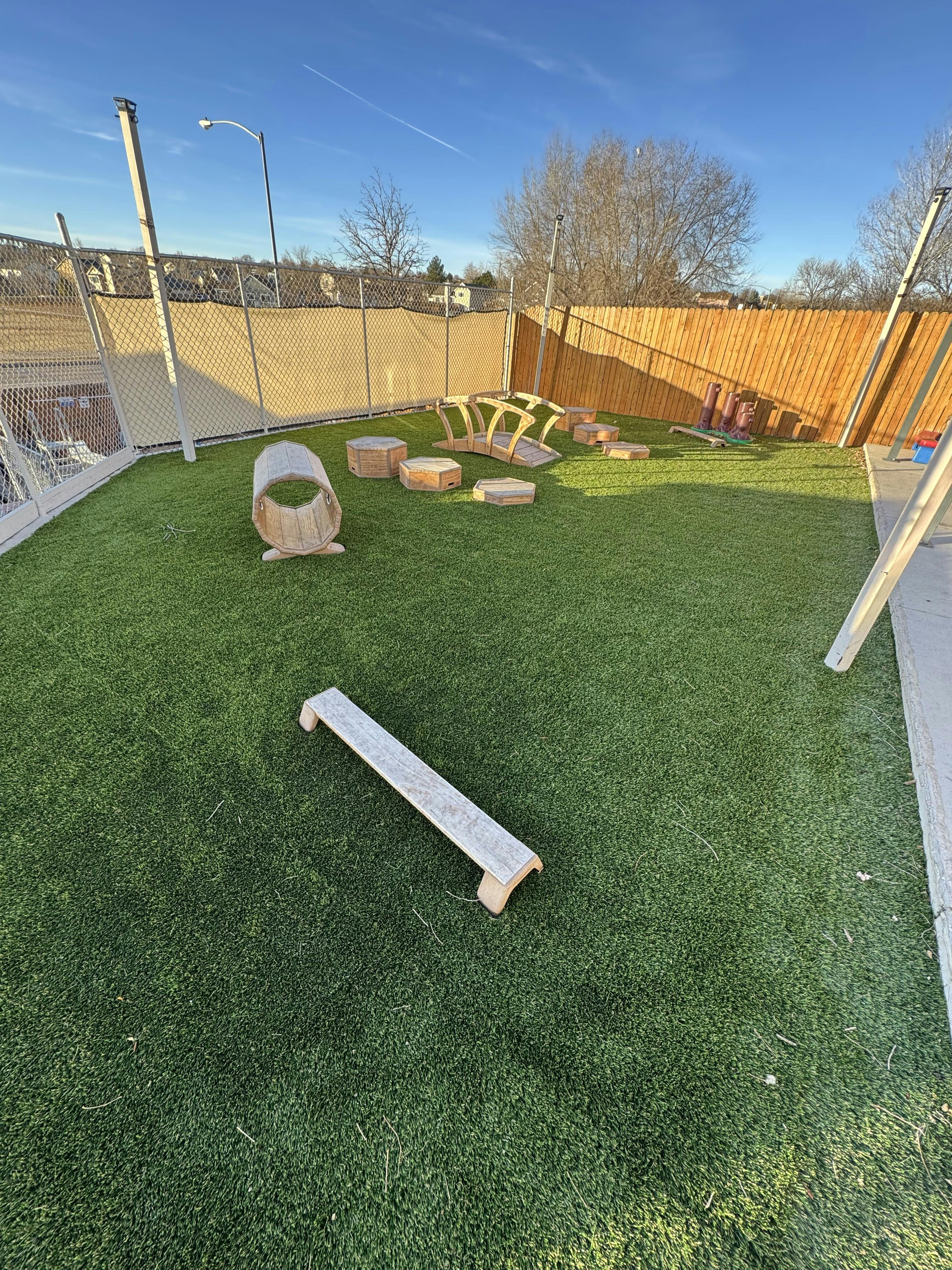 Outdoor play area with artificial turf and wooden play structures