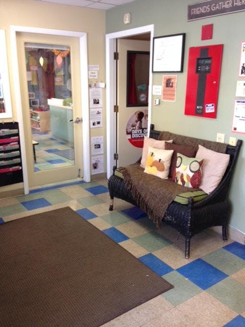 Lobby area with a wicker bench, throw pillows, and checkered floor tiles