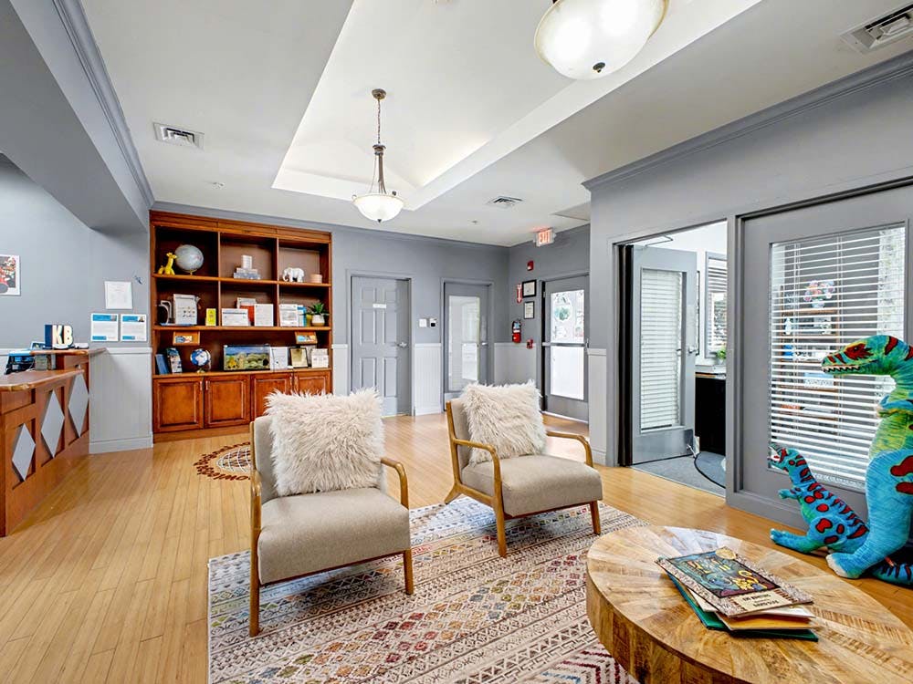 Lobby with wooden bookcase, seating area, and stuffed dinosaur toys