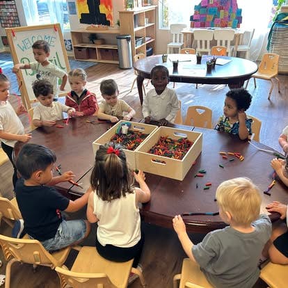 Children sitting around a table with craft supplies