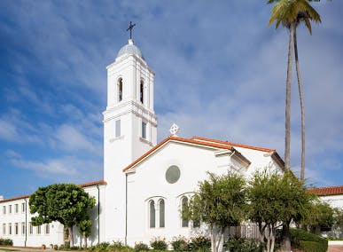 White church with a bell tower and cross against a blue sky