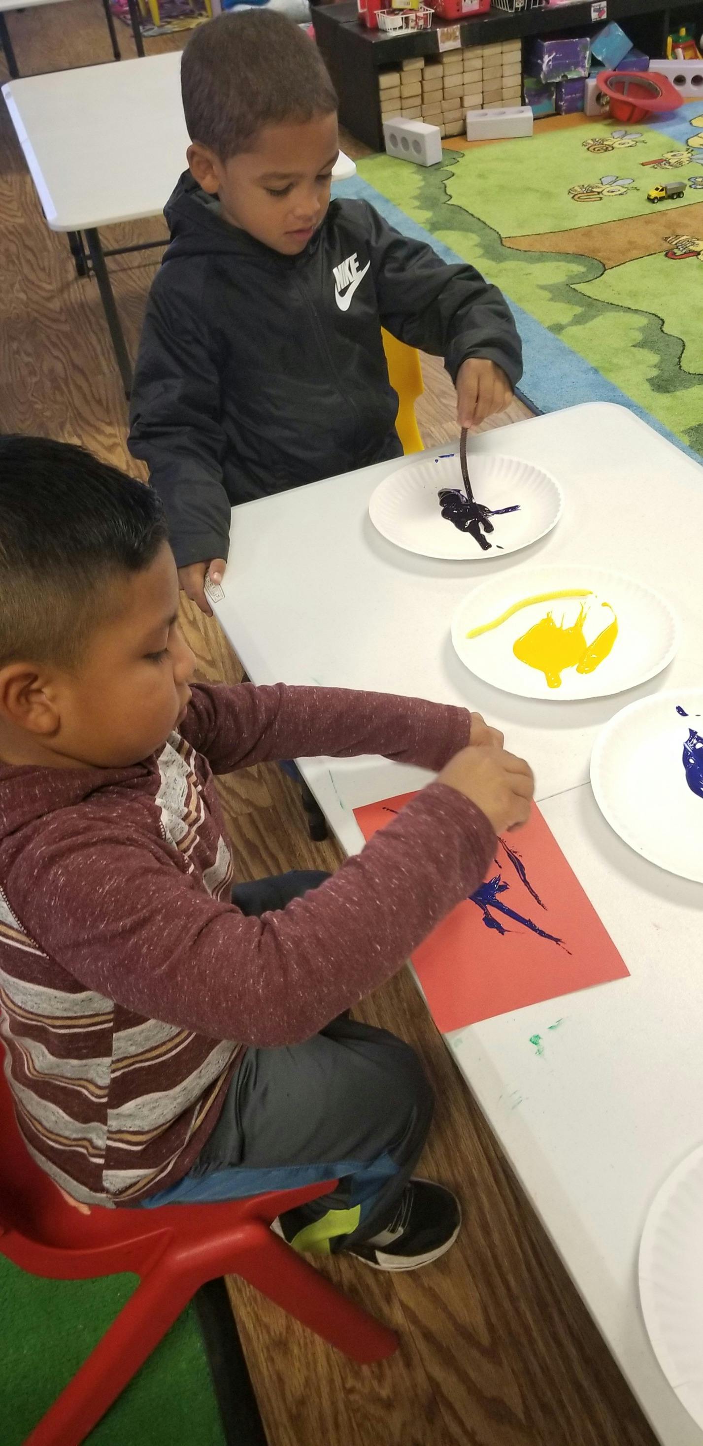 Two children painting at a table