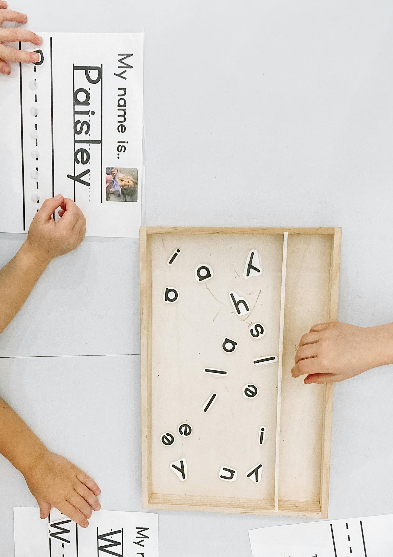 Children learning to spell their names with magnetic letters