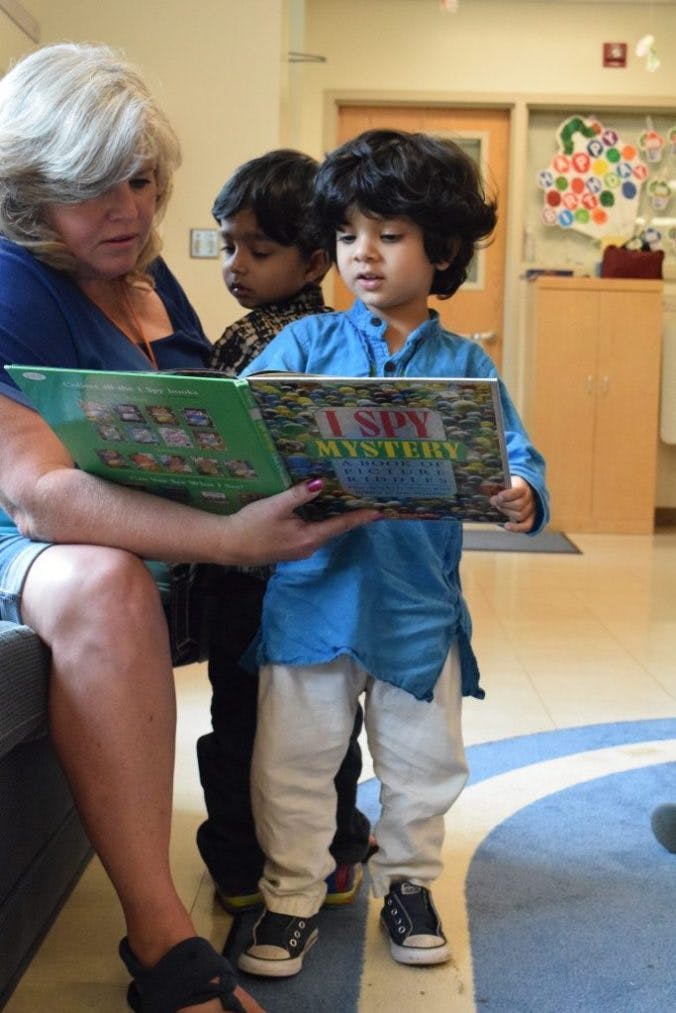 Person reading a book to two children