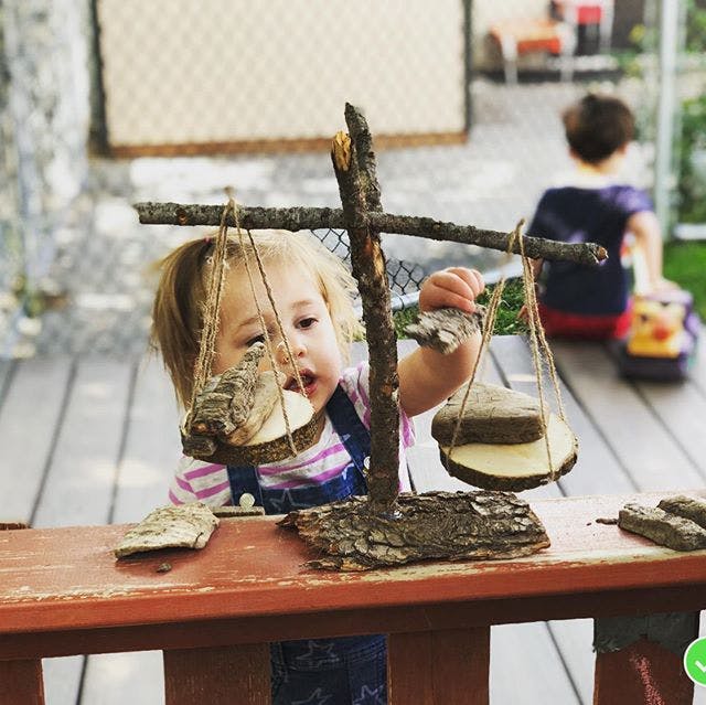 Child playing with a wooden balance scale