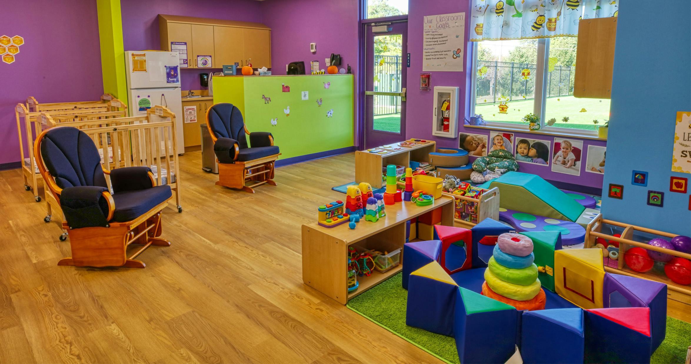 Colorful playroom with cribs, chairs, and soft play equipment