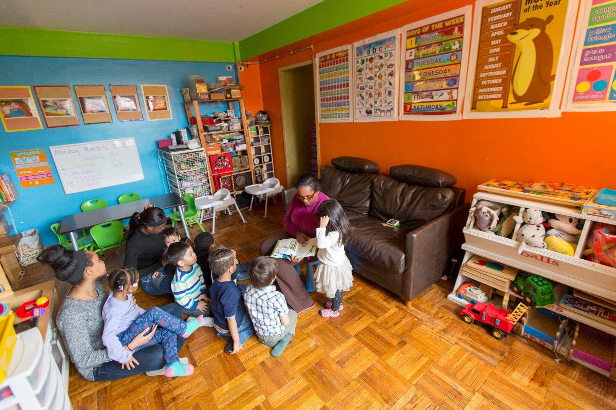 Adults and children sitting on the floor in a classroom