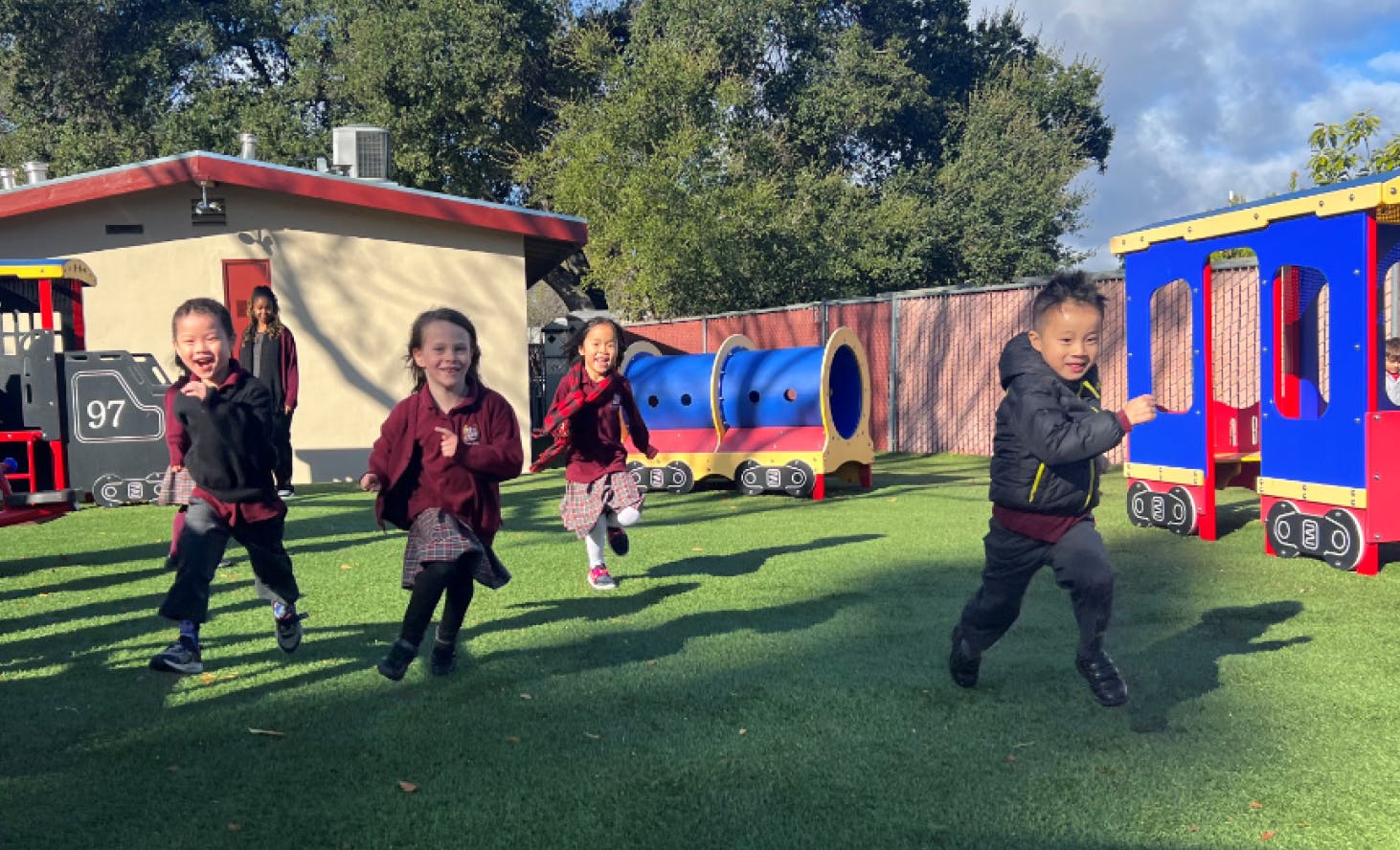 Children running on artificial grass in a play area