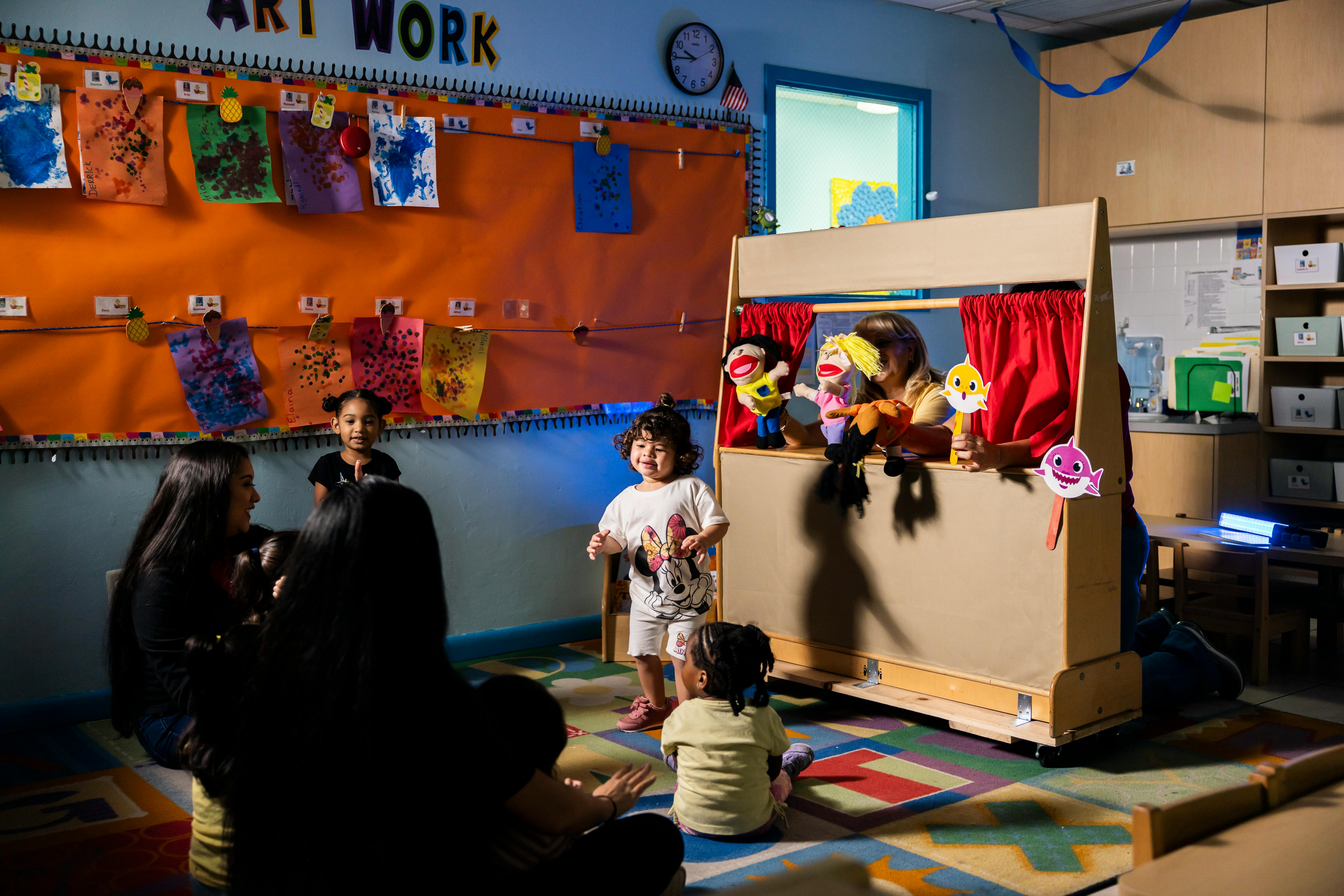 Children watching a puppet show in a classroom