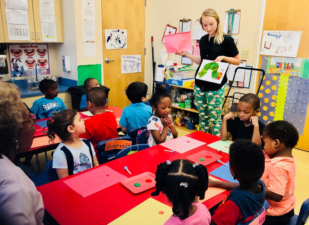 Adult teaching children in a classroom