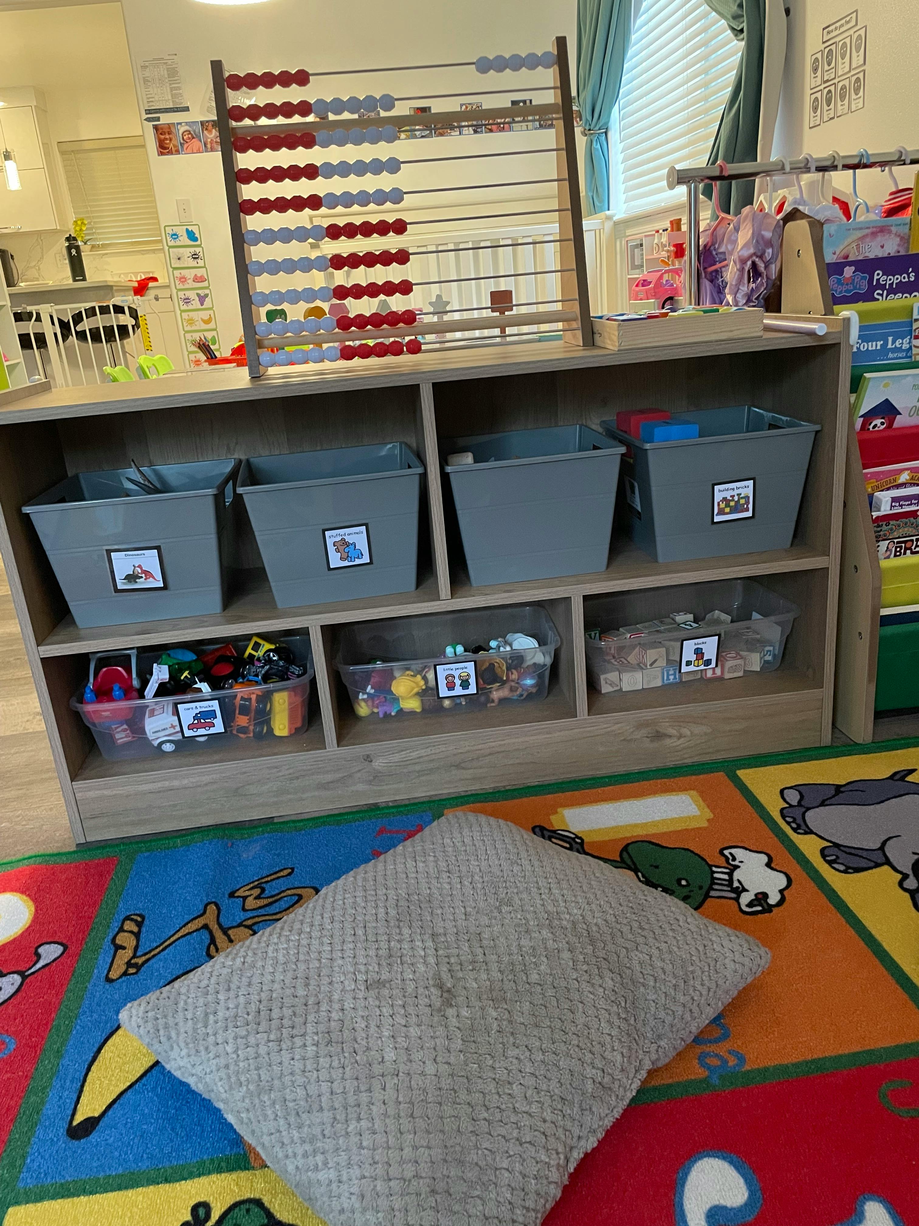 Abacus on a shelf with storage bins and toys in a classroom