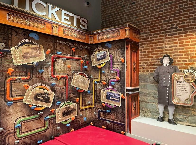 Exhibit with a wall display of historical tickets and a figure of a person