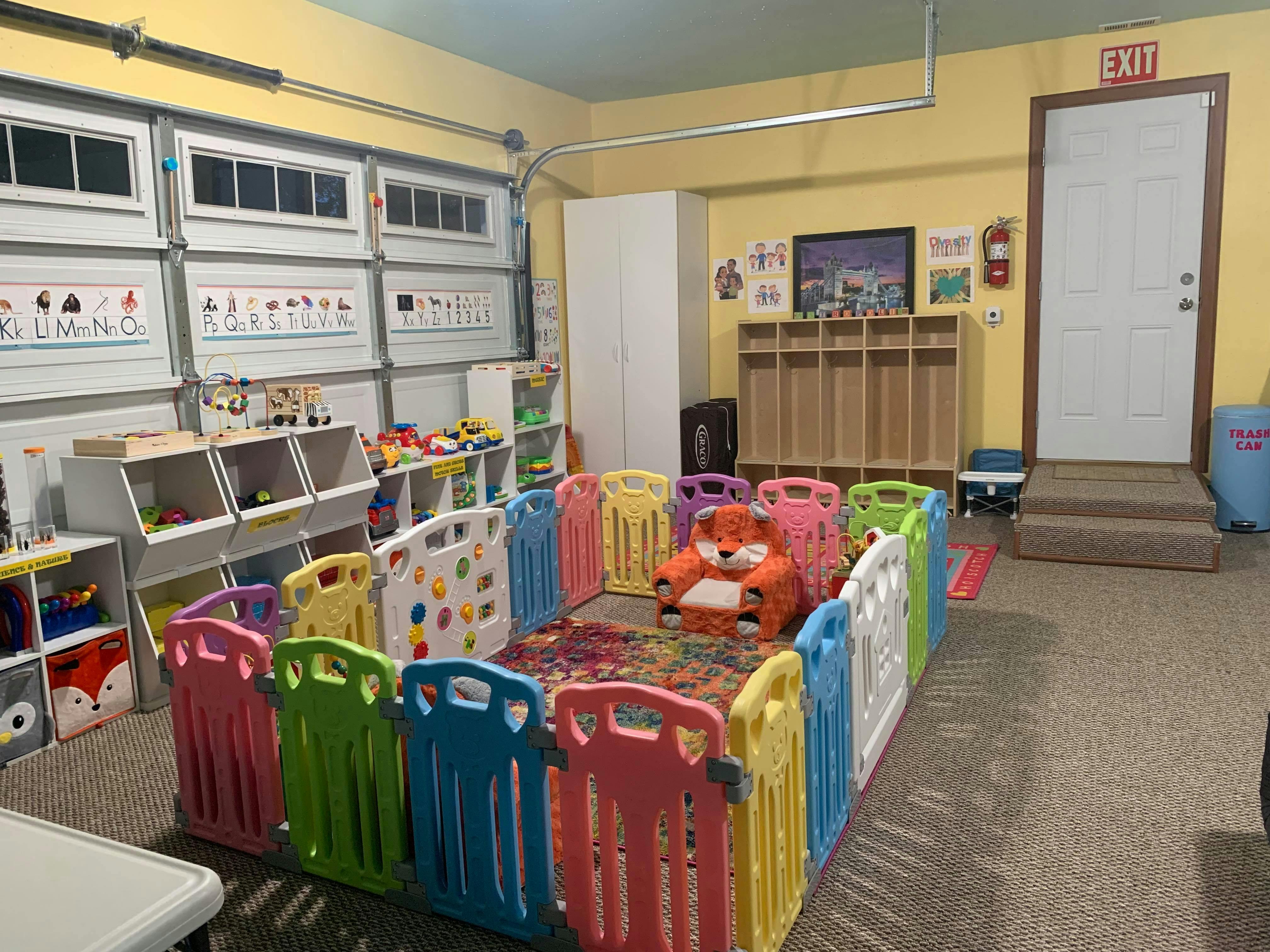 Play area with colorful fence, toy storage, and cubbies