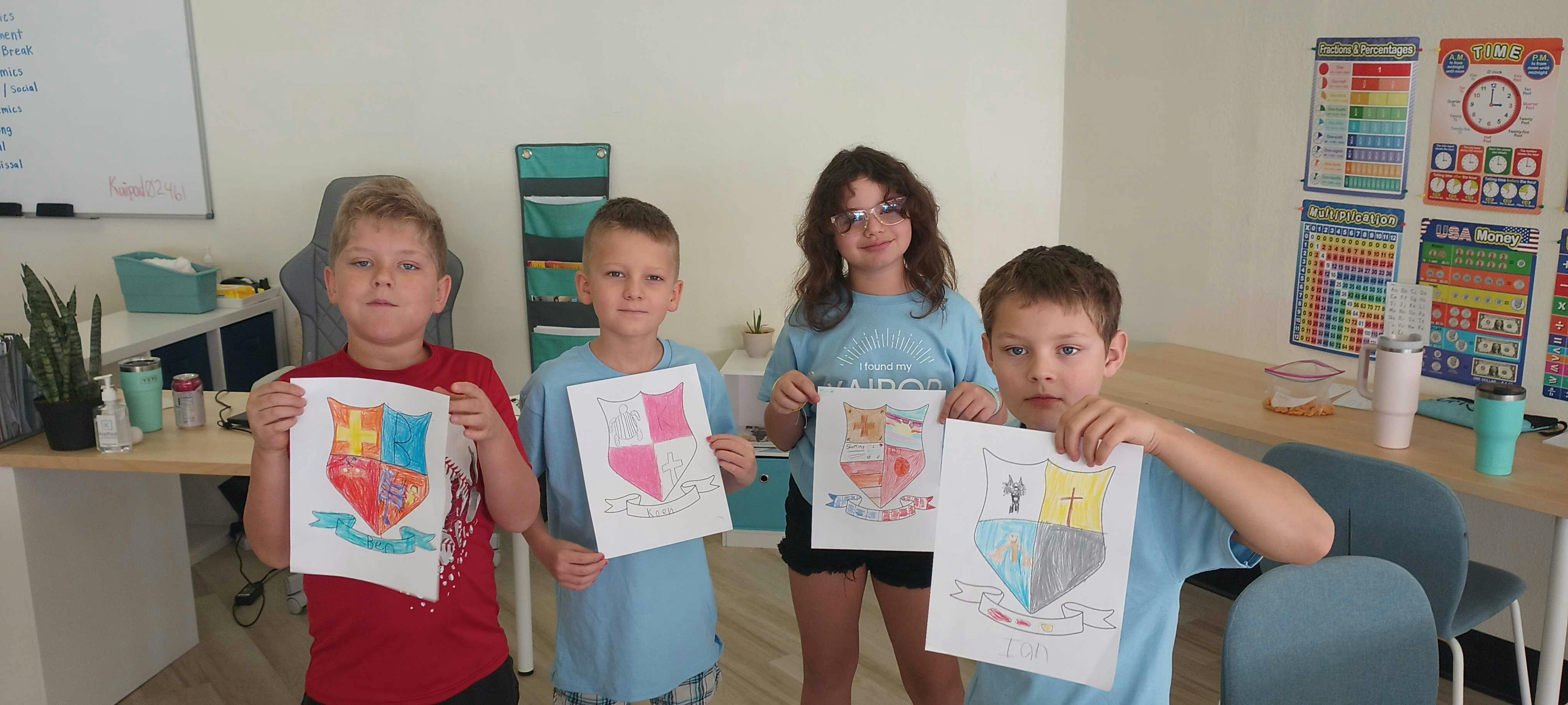 Four children holding up their drawings