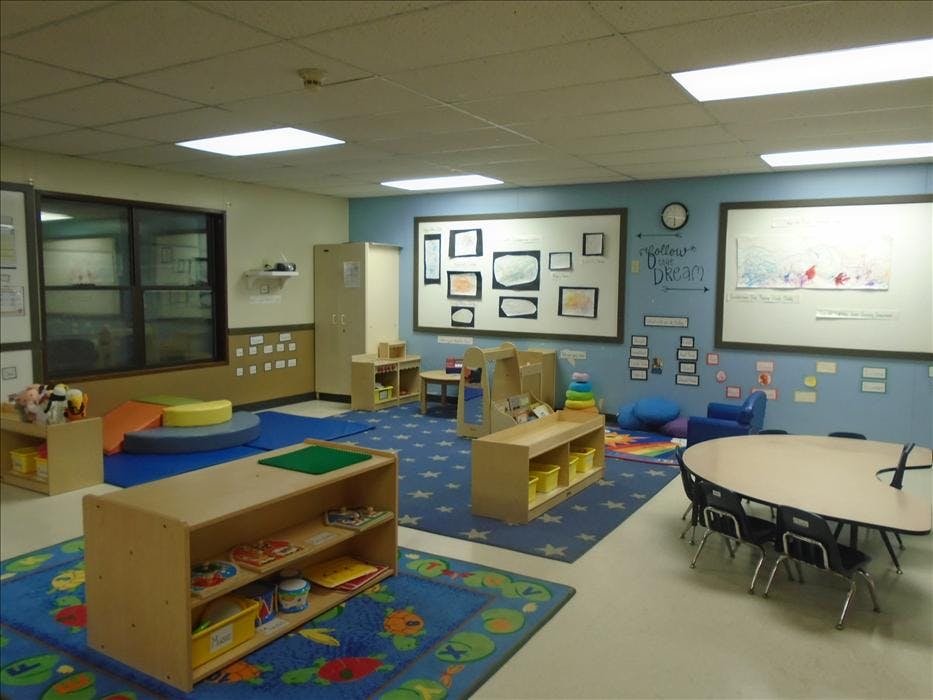 Classroom with child-sized furniture and colorful rugs