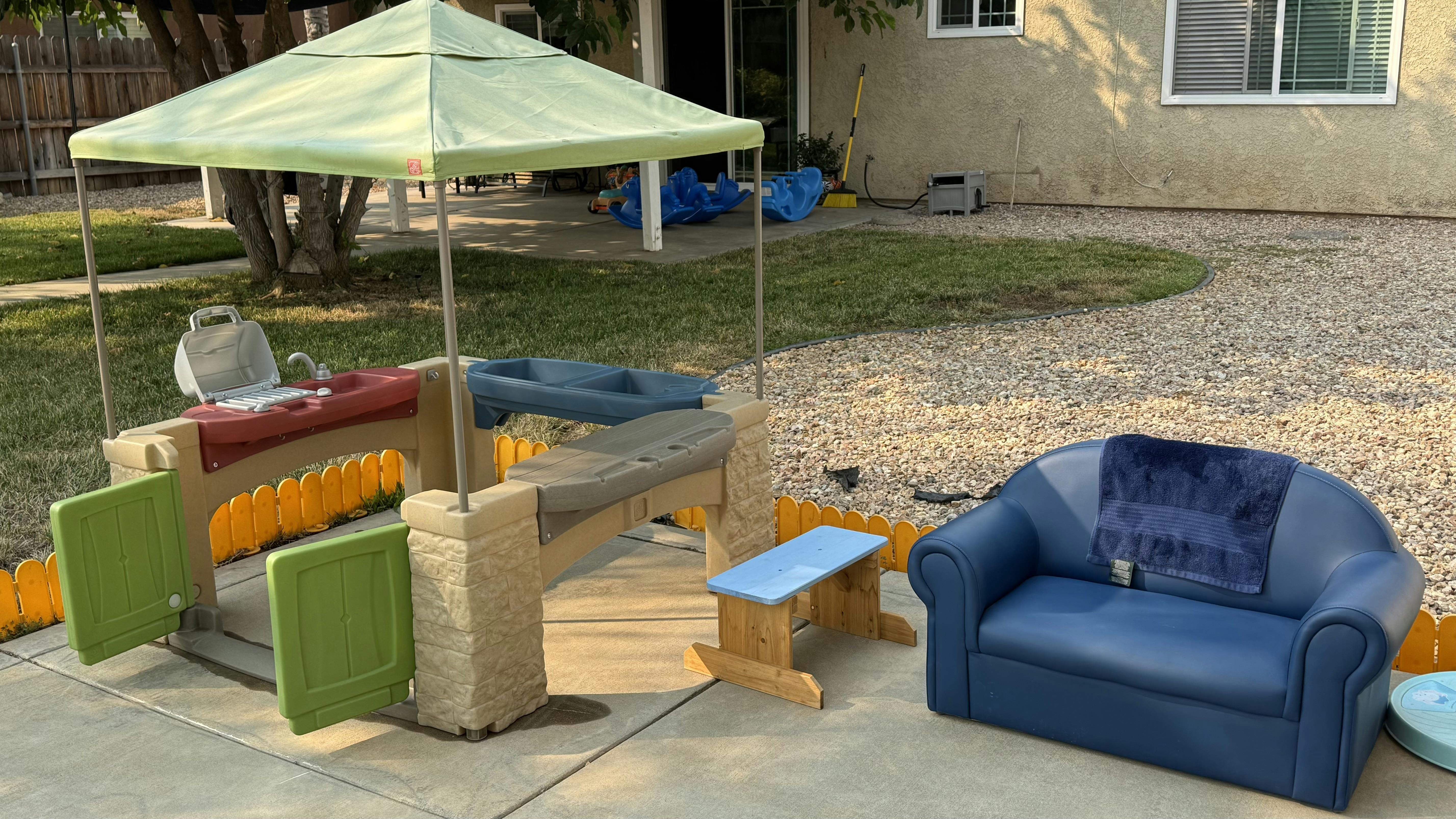 Play structure with canopy and blue couch on a patio