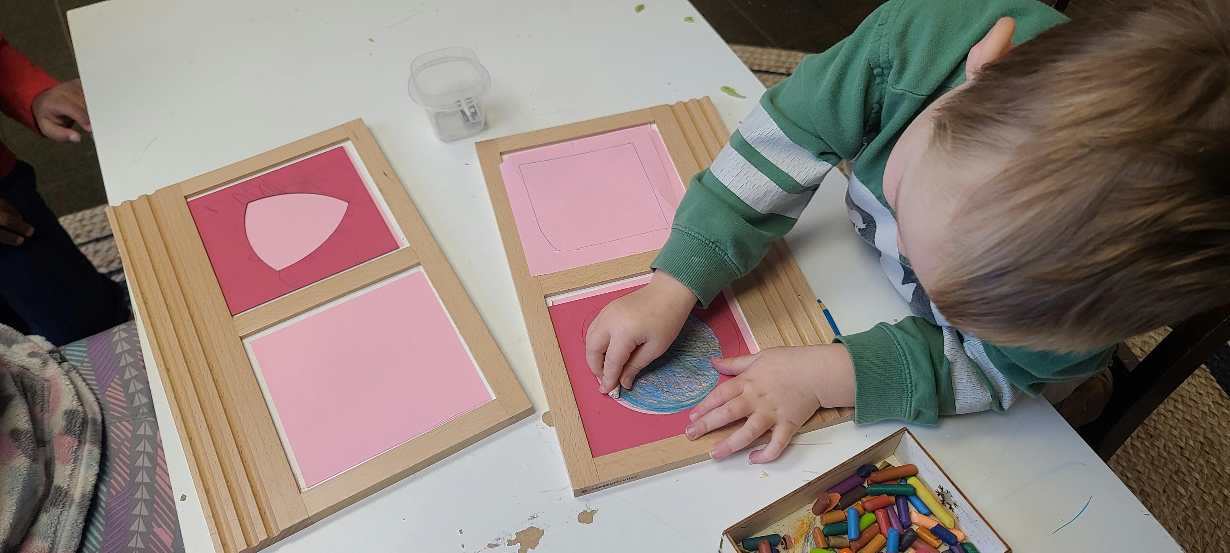 Child tracing a shape on a wooden board