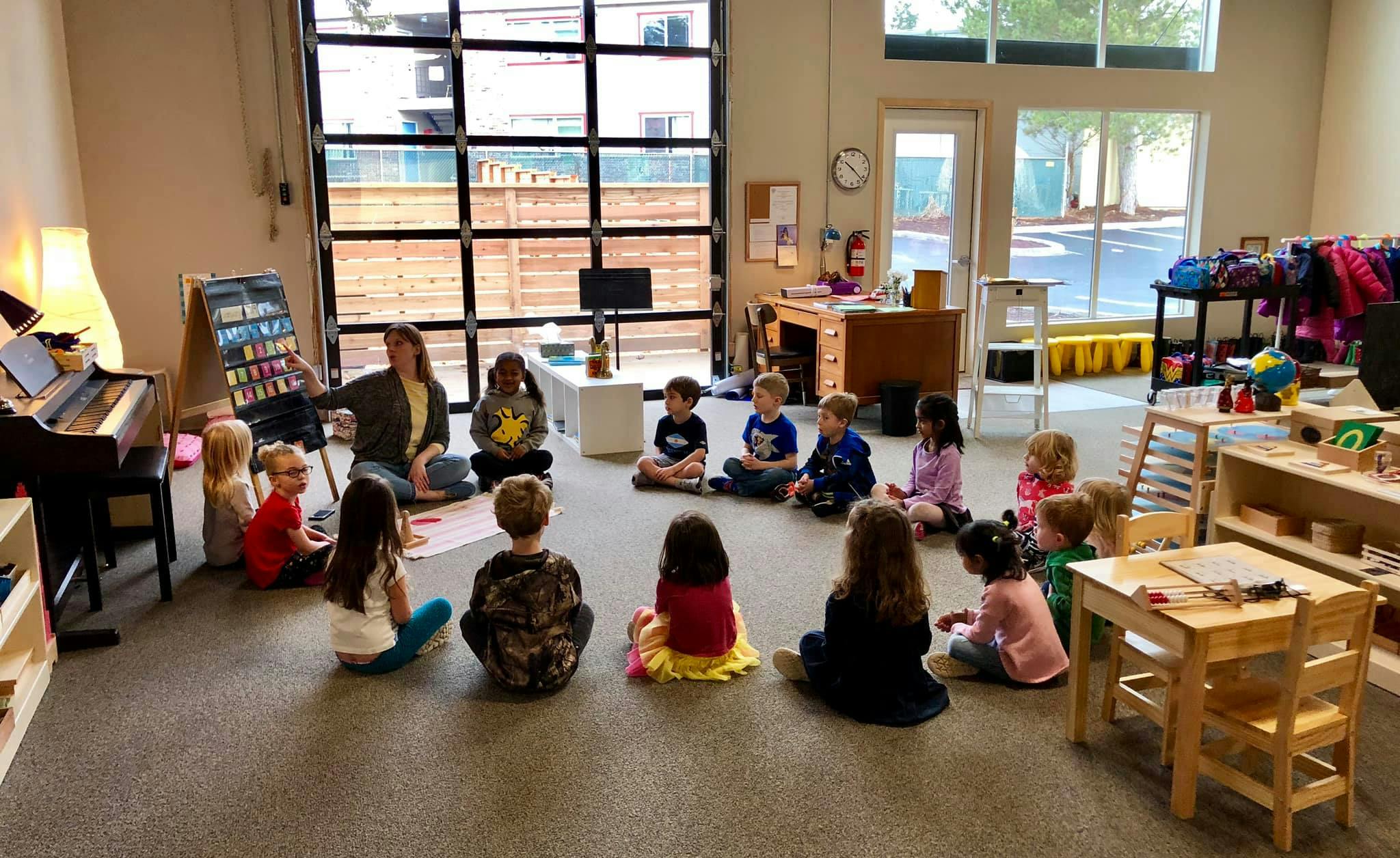 Adult teaching children sitting on the floor in a classroom