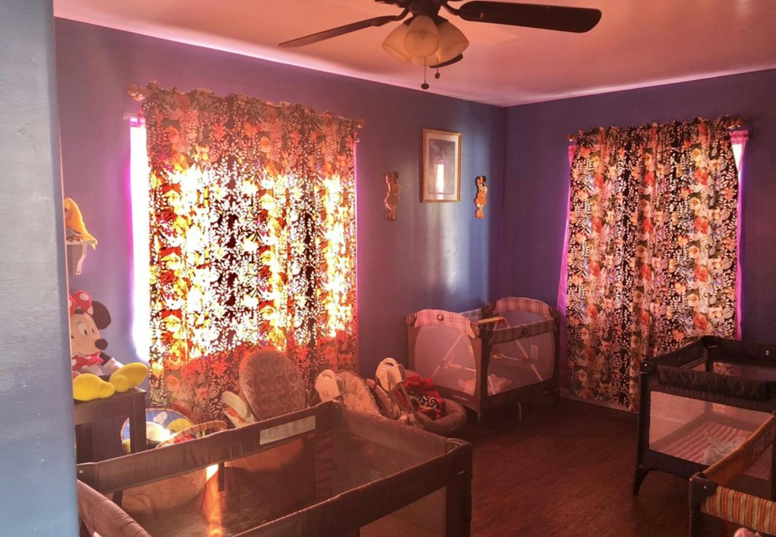 Room with two cribs and patterned curtains