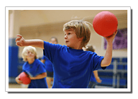 Child in blue shirt holding a red ball, preparing to throw