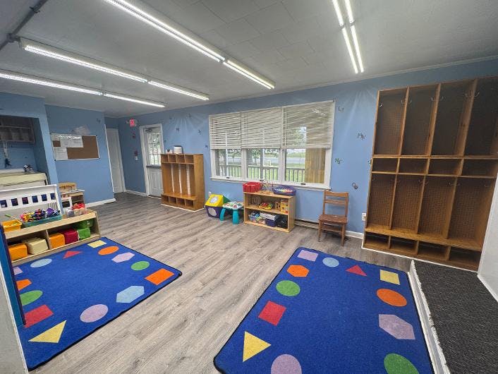 Classroom with wooden cubbies, floor rugs, and educational materials